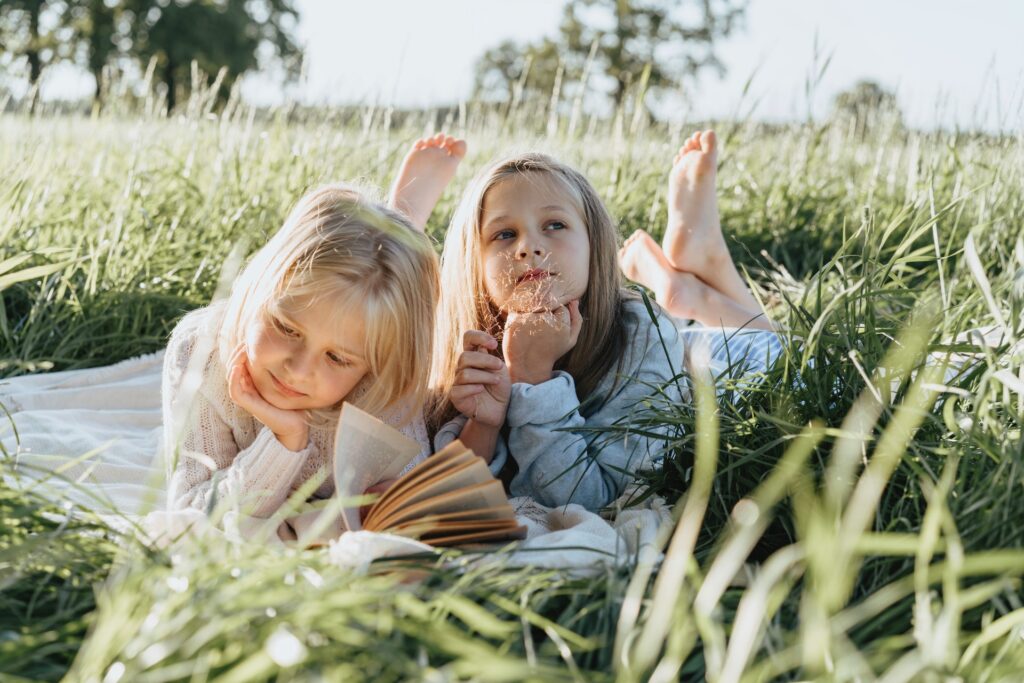 Classic Outdoor Games - Little Girls Lying on Green Grass Field