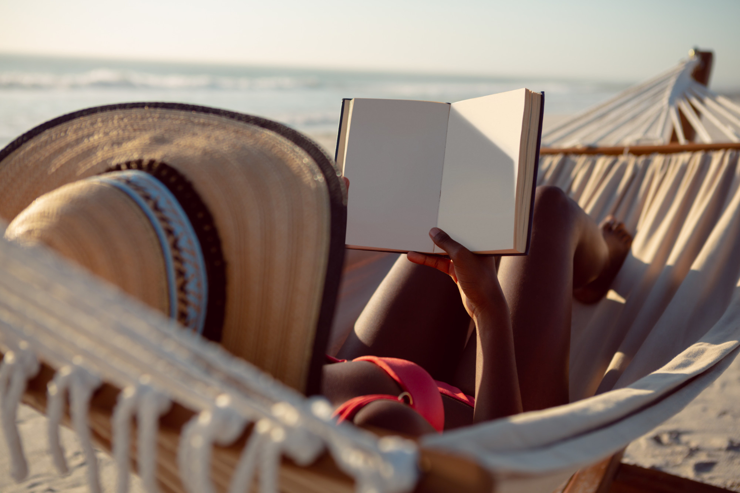 woman-reading-book-while-relaxing-hammock-beach